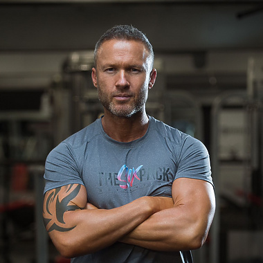 a person with arms crossed in a gym