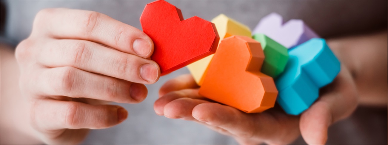 Person holding multicoloured love hearts