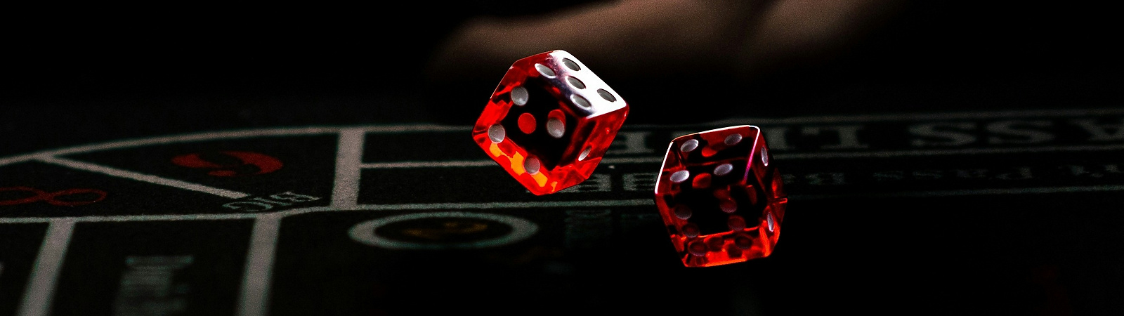 a hand throwing red dice