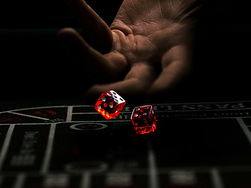 a hand throwing red dice