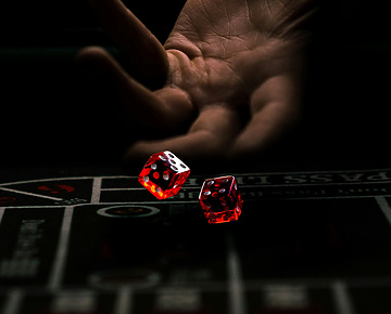 a hand throwing red dice