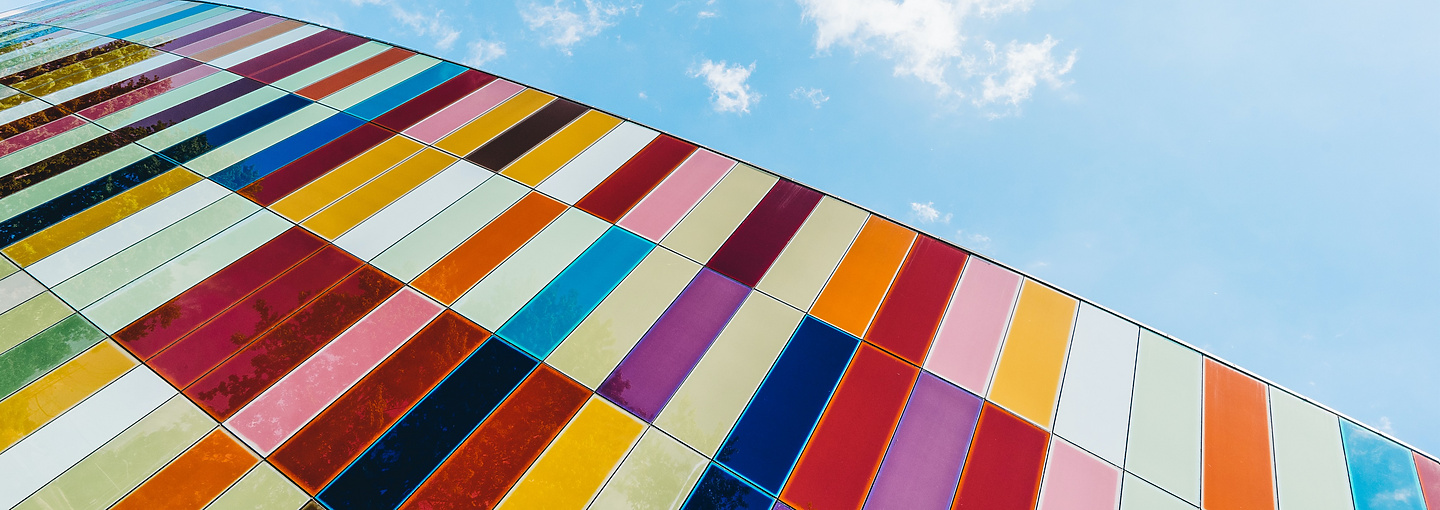 Multi colour panels cladding a building with camera facing skyward