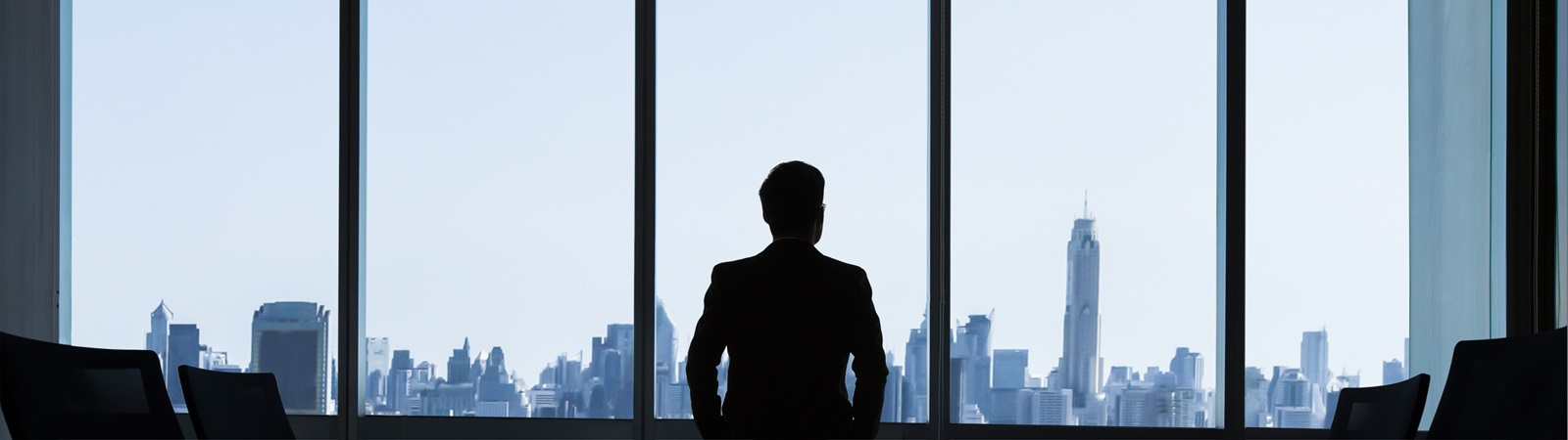man looking out of window of corporate office