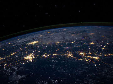 The earth from low level orbit at night featuring many illuminated cities