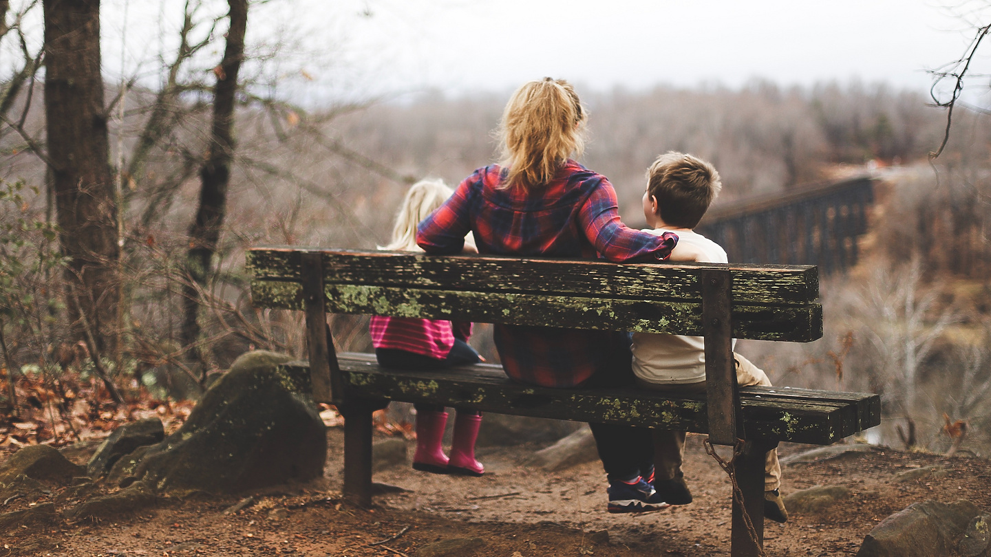 a person and children sitting on a bench