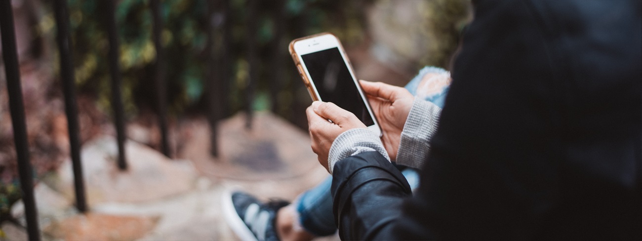 woman sitting on stairs using phone