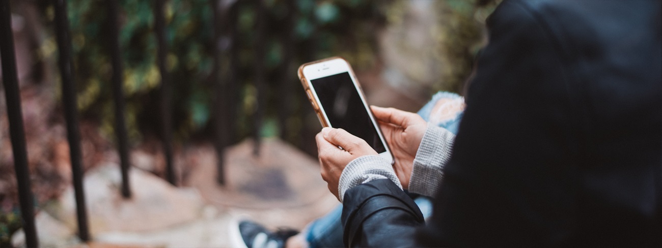 woman sitting on stairs using phone