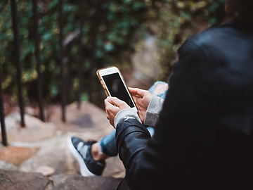 woman sitting on stairs using phone