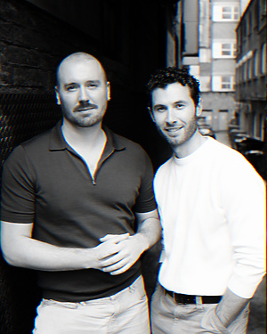Two men standing together in a narrow alleyway