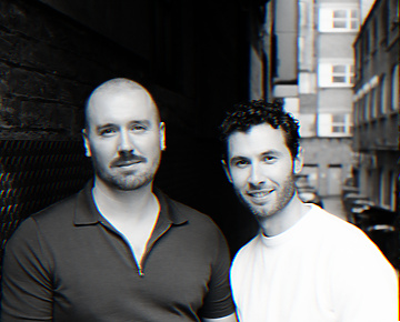 Two men standing together in a narrow alleyway