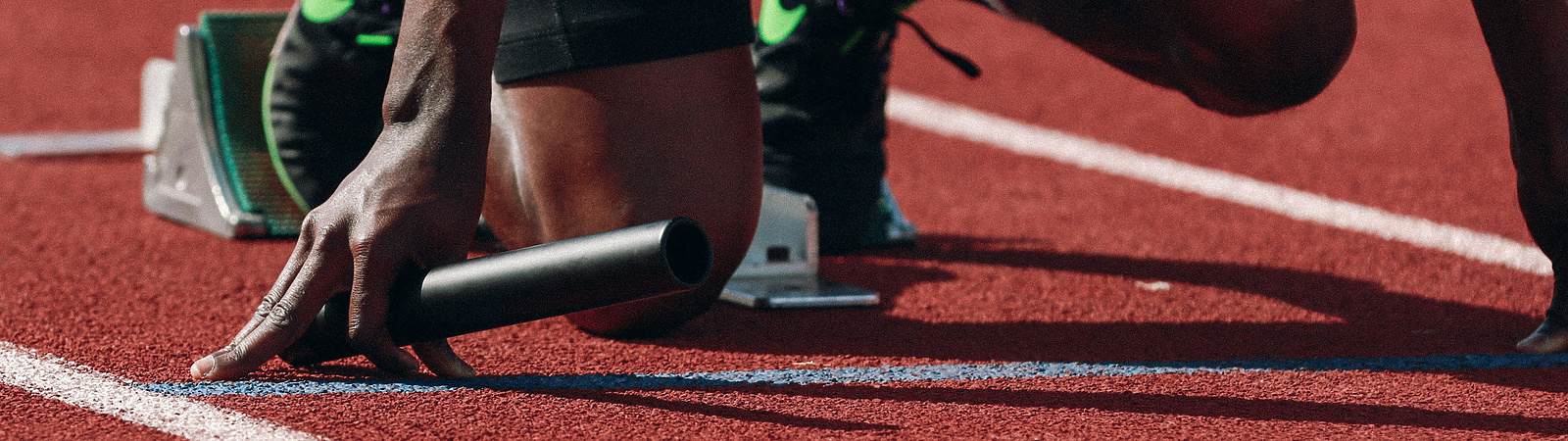 a person on a track holding a baton