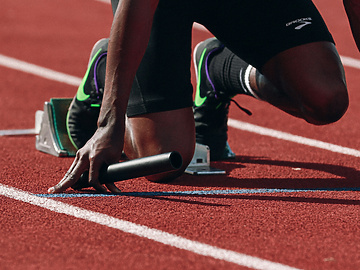 a person on a track holding a baton