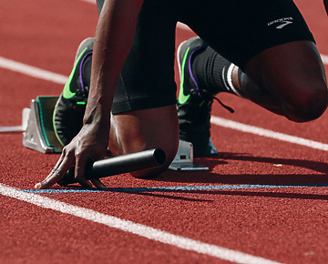 a person on a track holding a baton