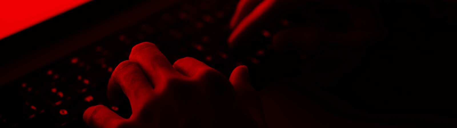 hands on a keyboard in the dark