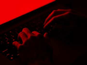 hands on a keyboard in the dark