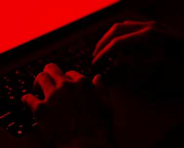 hands on a keyboard in the dark