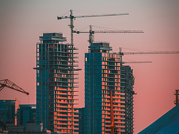 sunset over construction site with cranes in the background