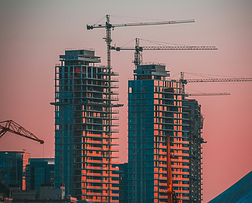 sunset over construction site with cranes in the background