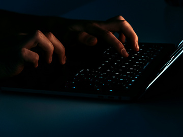 hands typing on a laptop keyboard