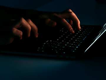 hands typing on a laptop keyboard