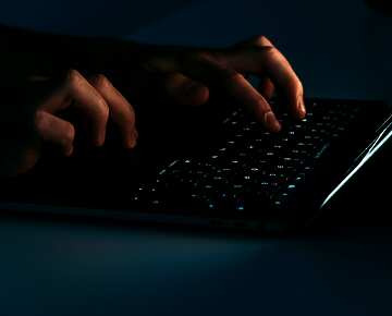 hands typing on a laptop keyboard