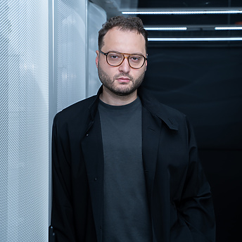 a person wearing glasses and a black coat