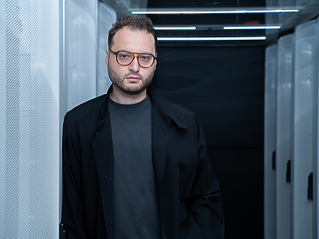 a person wearing glasses and a black coat
