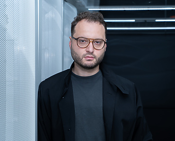a person wearing glasses and a black coat