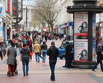 a group of people walking on a sidewalk