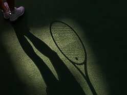 a shadow of a tennis player holding a racket
