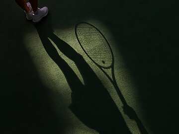 a shadow of a tennis player holding a racket