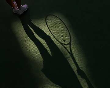 a shadow of a tennis player holding a racket