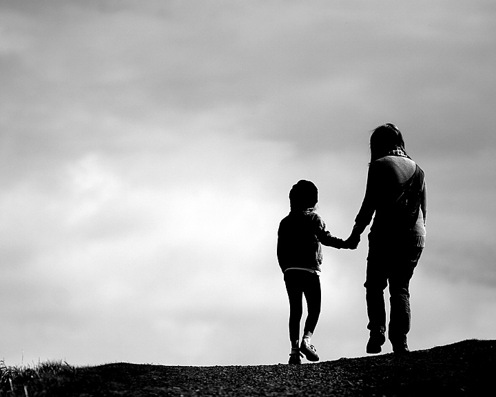 a person and child walking on a hill