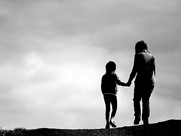 a person and child walking on a hill