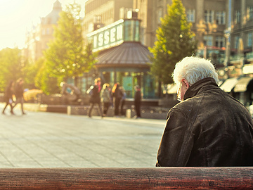a person sitting on a bench in a city