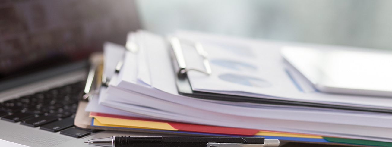 pile of documents on laptop