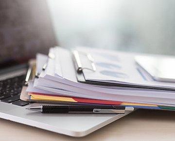 pile of documents on laptop