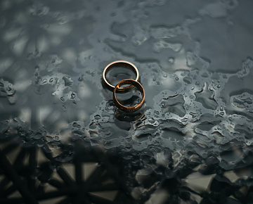a pair of gold rings on a wet surface