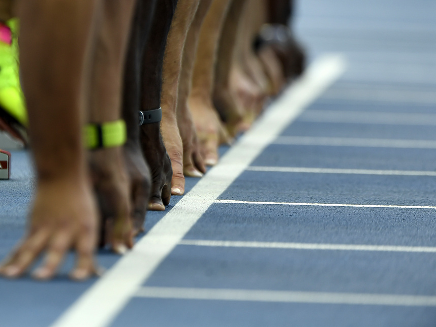 a close-up of people at the start line on a track