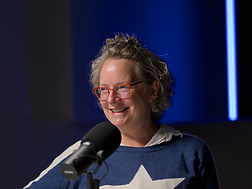 a person sitting at a table with a microphone
