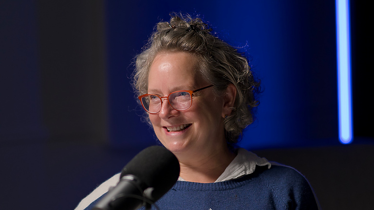 a person sitting at a table with a microphone