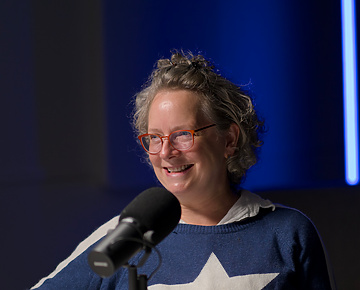 a person sitting at a table with a microphone
