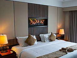 a bed with a lamp and a wall mounted fireplace