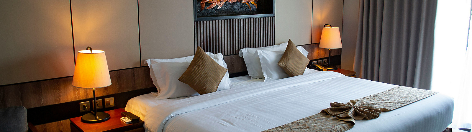 a bed with a lamp and a wall mounted fireplace