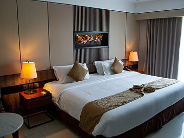 a bed with a lamp and a wall mounted fireplace