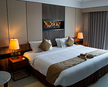 a bed with a lamp and a wall mounted fireplace