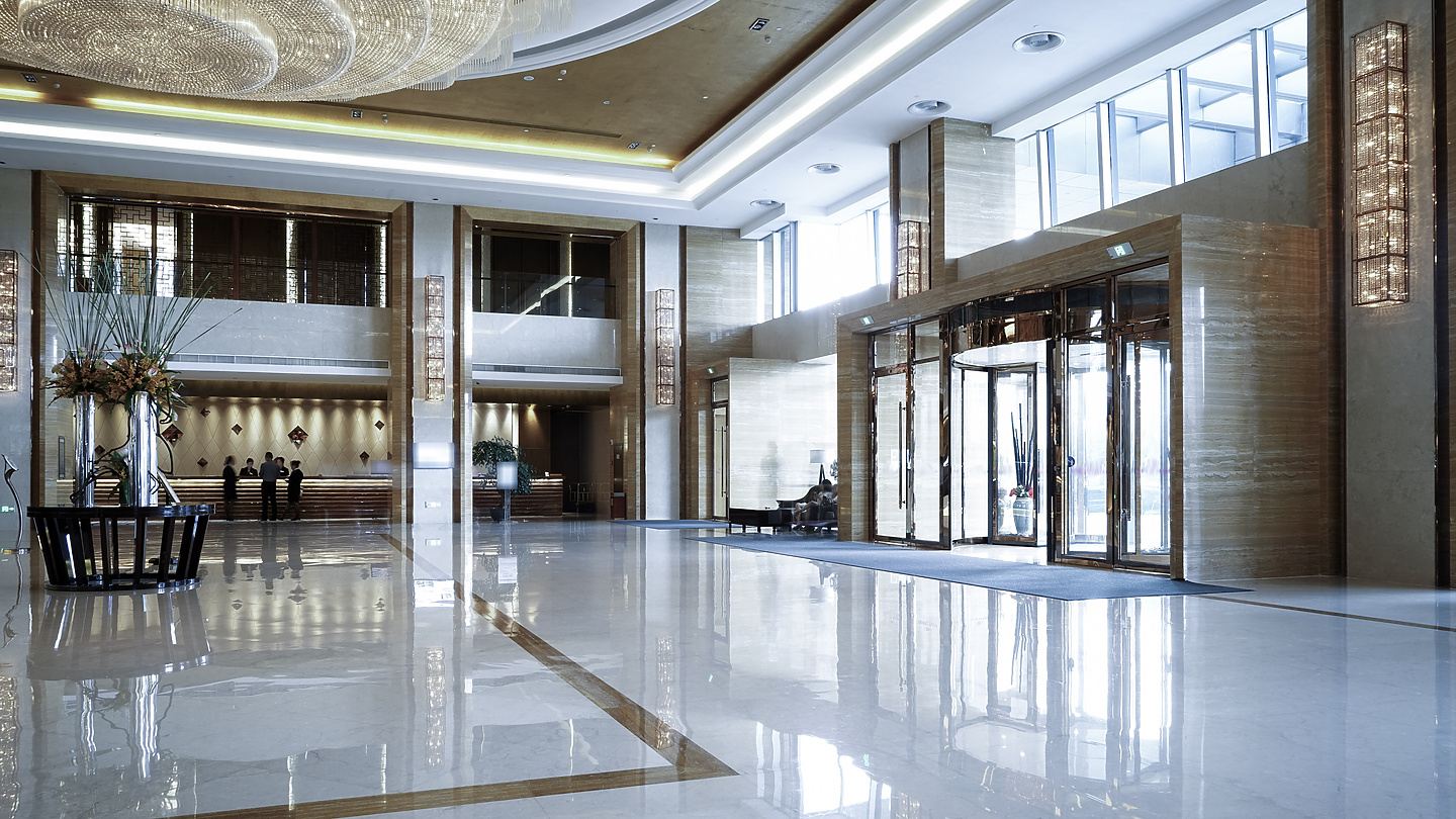 a large hall with glass doors and a chandelier
