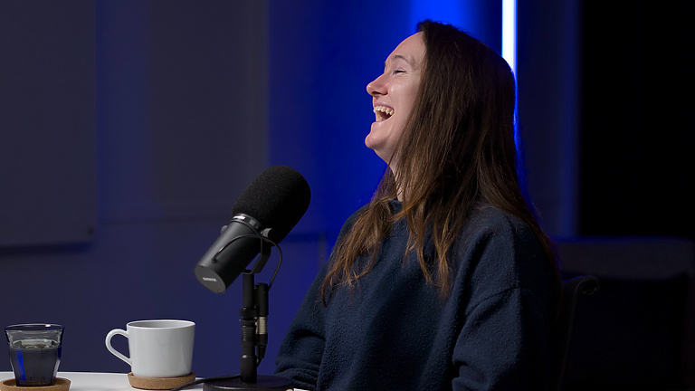 a person sitting at a table with a microphone and a book