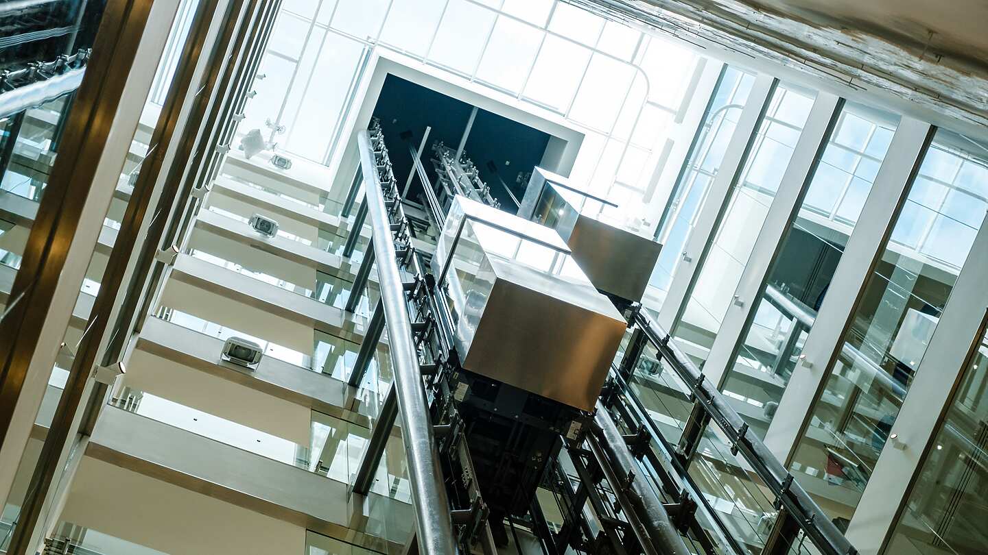 a glass elevator with a rectangular object in the middle
