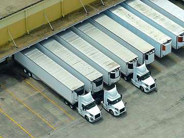 a group of semi trucks parked in a warehouse
